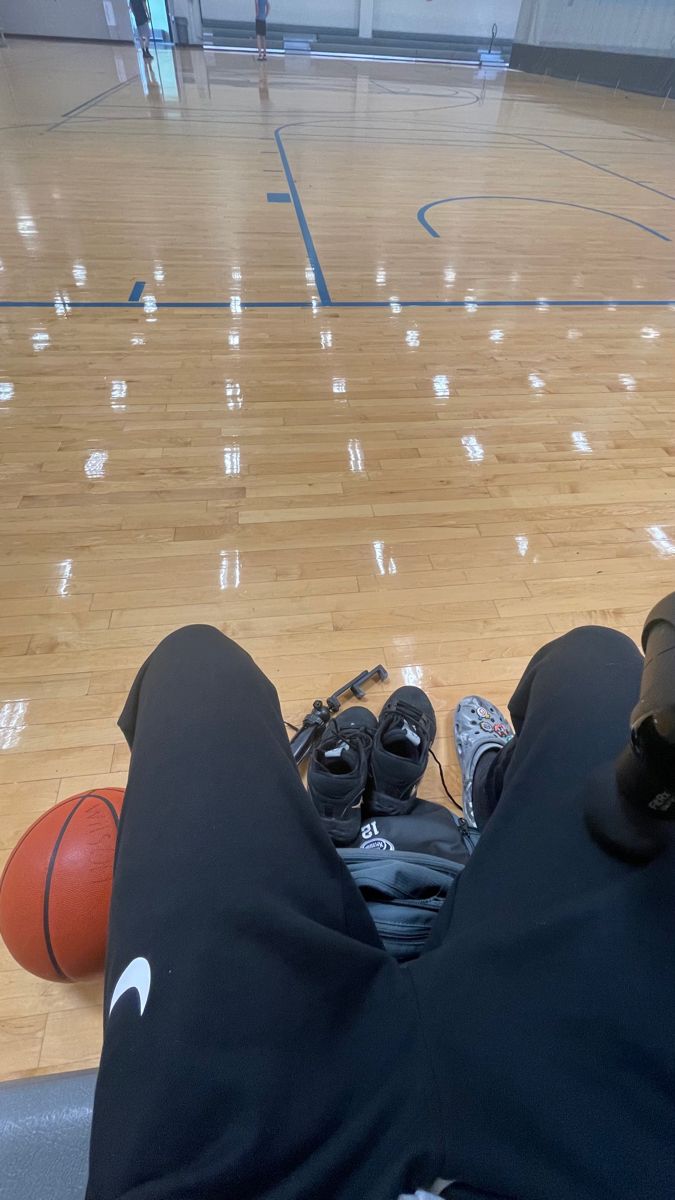 someone is laying on the floor with their feet up in front of an orange ball