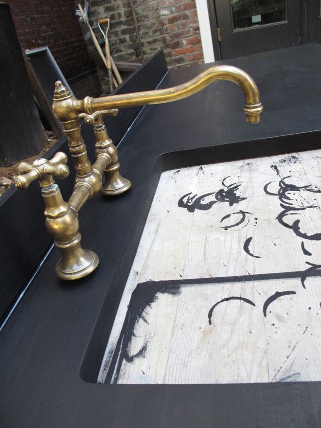 a black counter top with gold faucets on it