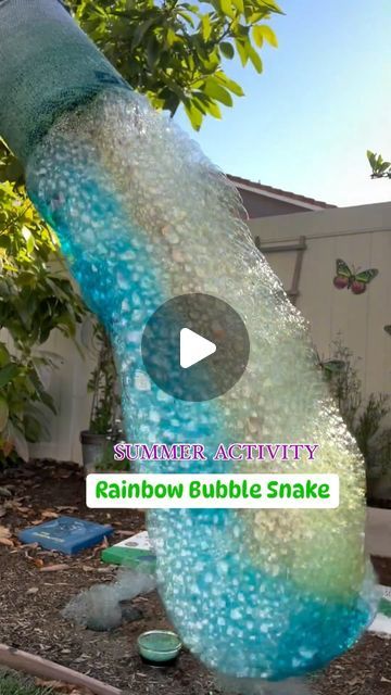 the rainbow bubble snake is on display in front of a tree and some other items