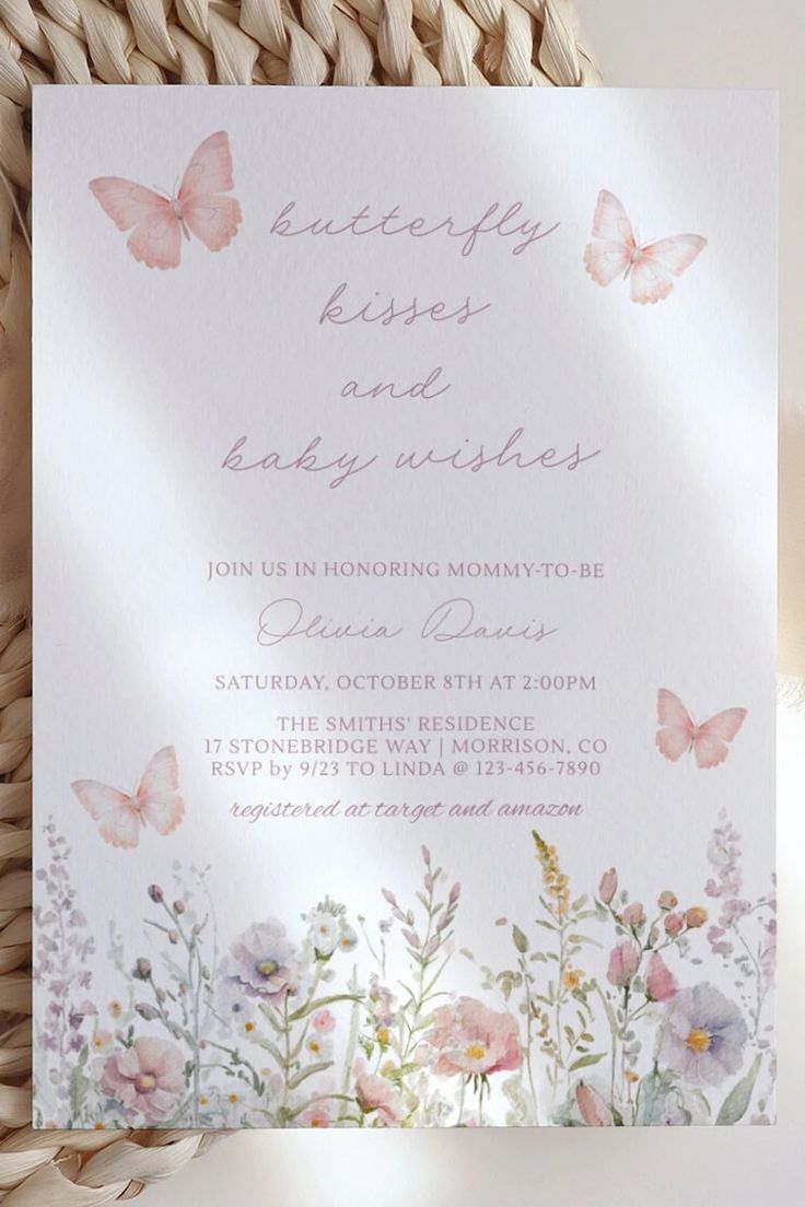 a white card with pink flowers and butterflies on it, next to a wicker basket