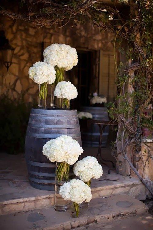 some white flowers are sitting in a vase on the steps outside an old stone building