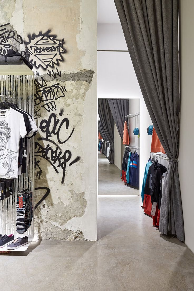 a room with graffiti on the walls and clothes hanging up in it's closet