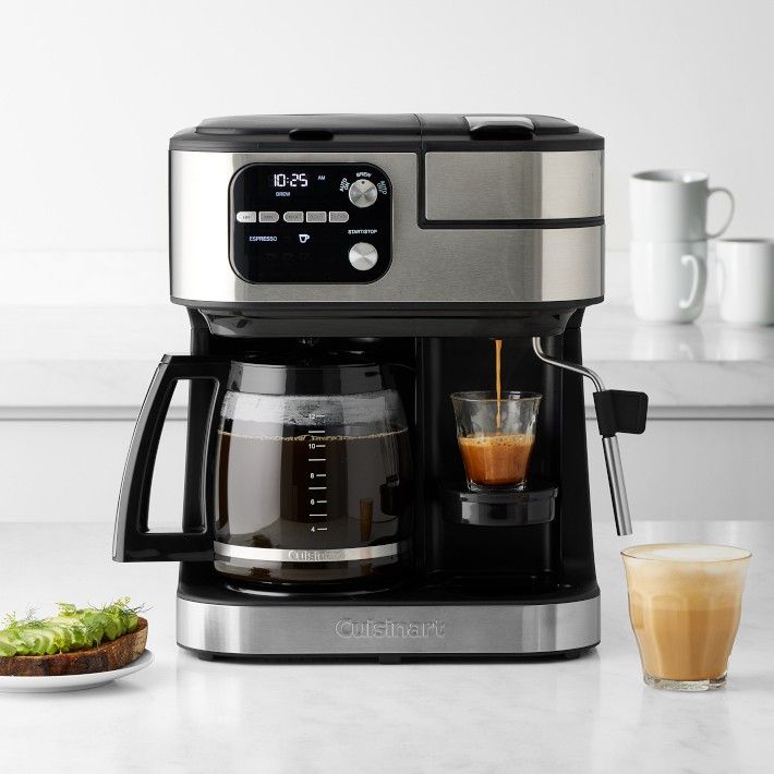 a coffee maker sitting on top of a counter next to a plate of food and a glass