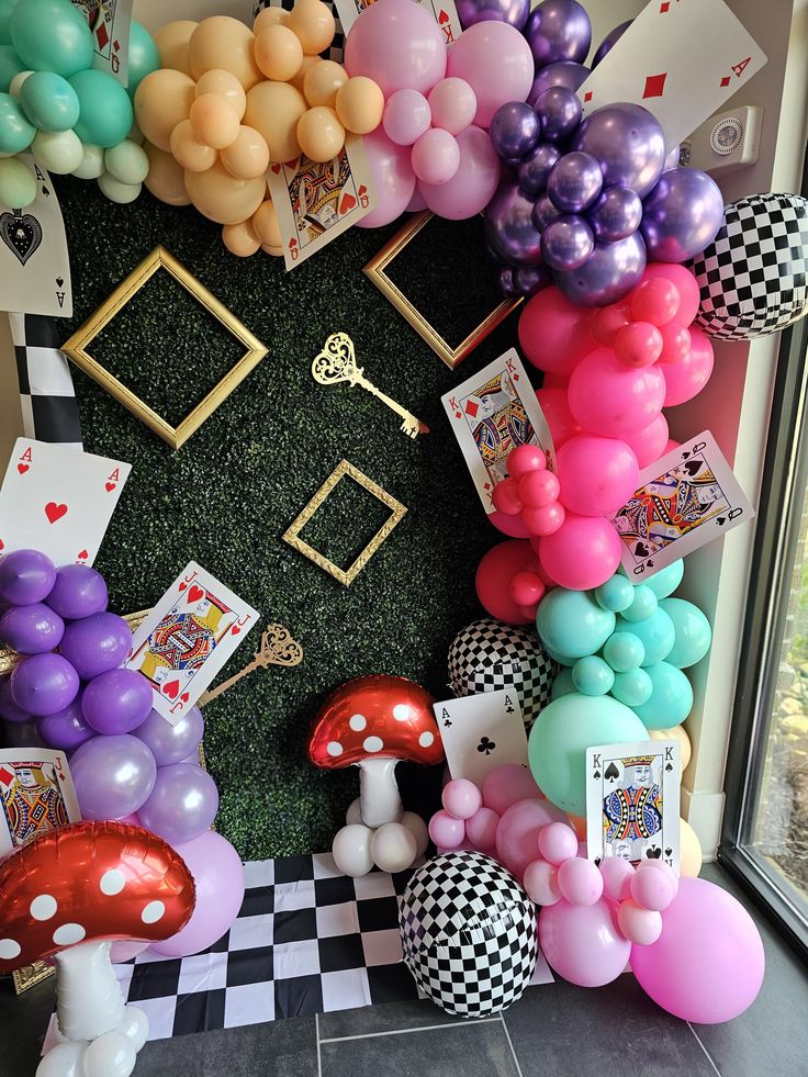 a room filled with balloons and pictures on the wall next to a door that has a checkered floor