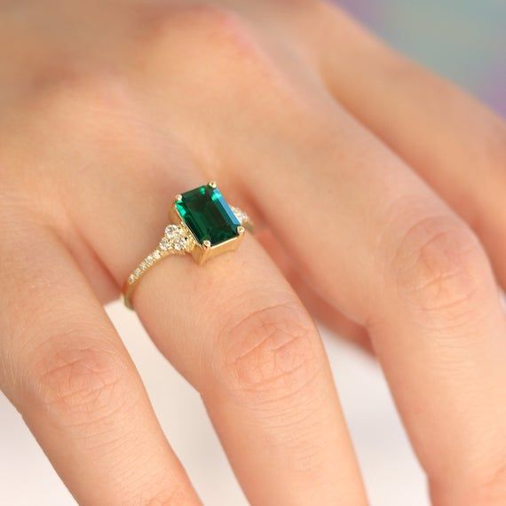 Handmade by an inspired jewelry artist team with decades of experience in the craft of jewelry making.Each gemstone, each diamond is carefully picked.Using only the finest raw materials and the highest industry standard in manufacturing, design and finish.A beautiful vintage inspired piece handmade just for you.An impressive radiant cut emerald brings rich color to this ring, contrasted by brilliant diamond side stones set in a shimmering 10,14 or 18 Karat gold setting.Ring Features:- Gemstone i 14k Gold Green Diamond Princess Cut Ring, Green Princess Cut Diamond Ring In 14k Gold, Princess Cut Green Diamond Ring In 14k Gold, Emerald Jewelry With Brilliant Cut For Proposal, Classic Emerald Cut May Birthstone Rings, Brilliant Cut Emerald Jewelry For Proposal, Classic Emerald Ring With Center Stone For Proposal, Emerald Ring With Center Stone In Baguette Cut, Emerald Ring With Baguette Cut Center Stone