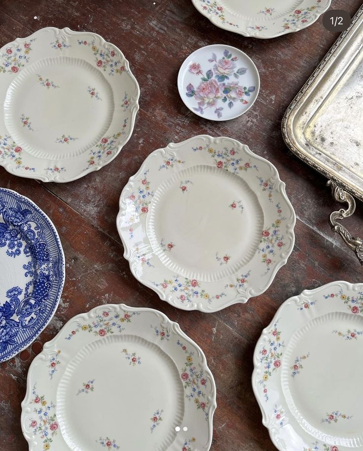 several plates are laid out on the floor next to an antique silver tray and mirror