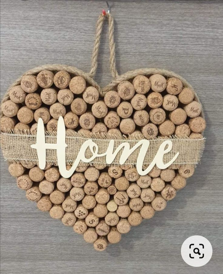 a heart shaped wine cork decoration with the word home written in white letters on it