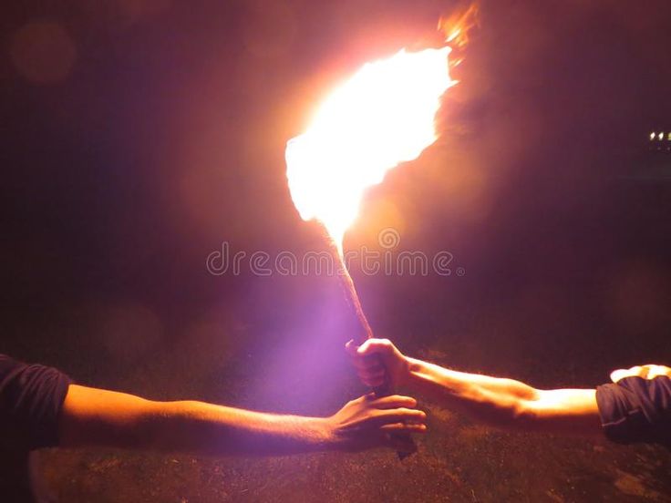 two hands holding a torch in the dark with bright light coming from it stock photos