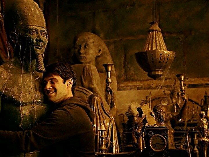 a man leaning against a statue in a room