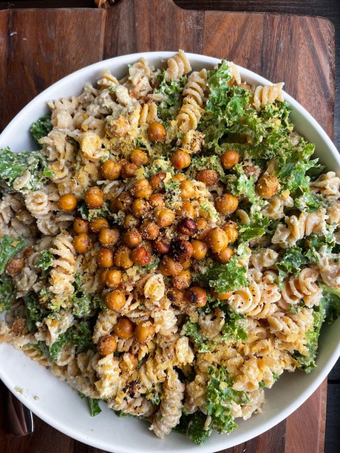 a white bowl filled with pasta, broccoli and chickpeas