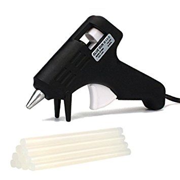 a black and white stapler next to four plastic dowels