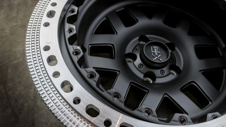 the front wheel of a vehicle with black spokes and silver tips on it's rim