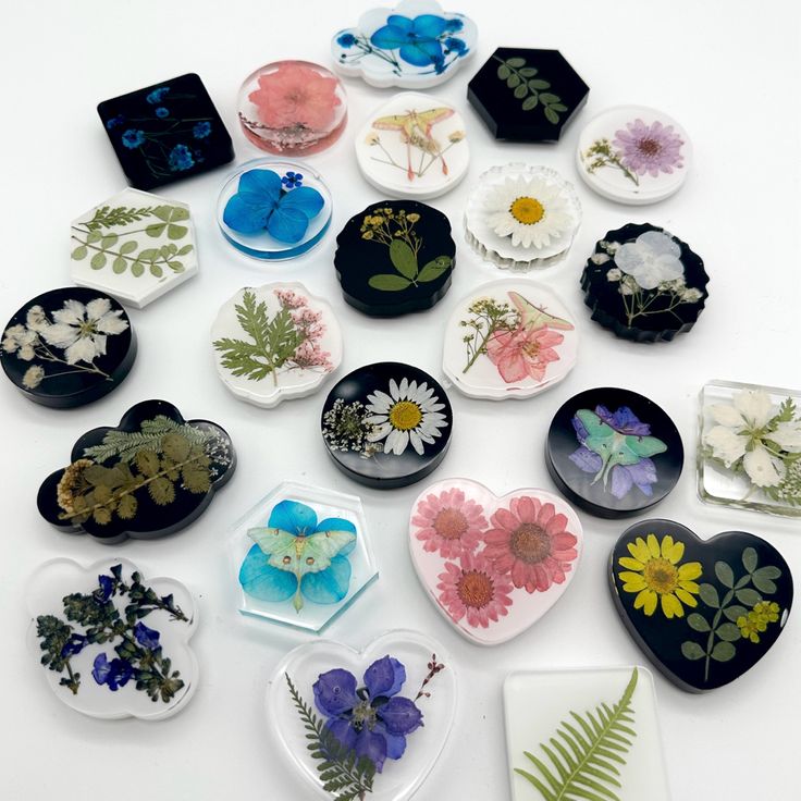 many different flowers and leaves are arranged in the shape of heart plates on a white surface