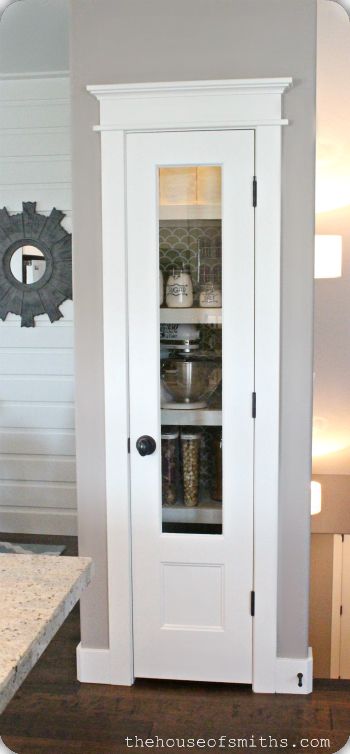 a white cabinet with glass doors in a kitchen