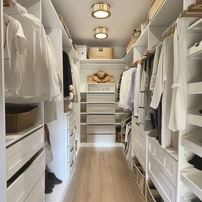 a walk in closet filled with lots of white drawers and shelves next to a wooden floor