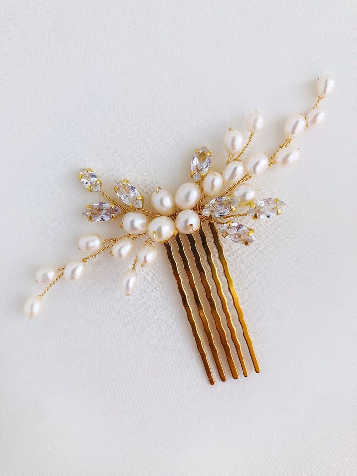 "Add elegance to your style with freshwater pearl comb and Zirconia cubes. The pearls are all one of a kind, high quality. Use this pearl hair comb to accentuate an updo or add a whimsical touch to loose waves. This bridal hair comb is versatile and can complement any wedding gown design. Size (wicker piece): 10 cm x 3 cm (4\"x 1.2\") *Choosing a color you choose the color of the wire products. Is it gold or silver wire color (choose the color of your jewelry or details on the dress)" Gold And Pearl Hair Accessories, Bridal Hair Accessories Pearl, Pearl Hair Jewelry, White Flower Hair Piece, Pearl Bridal Hair Comb, Pearl Headpiece Wedding, Pearl Hair Accessories, White Hair Accessory, Pearl Hair Piece