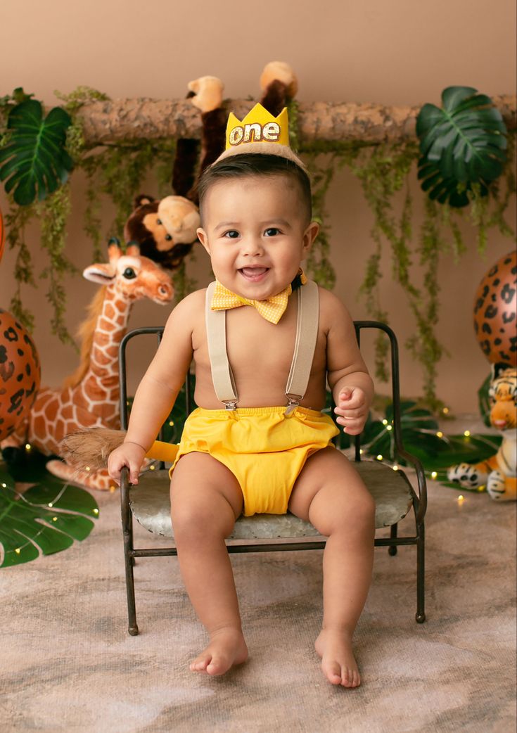 a baby sitting in a chair wearing a yellow diaper and a one - piece