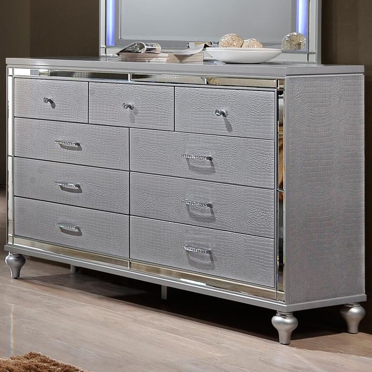 a silver dresser with drawers and a mirror