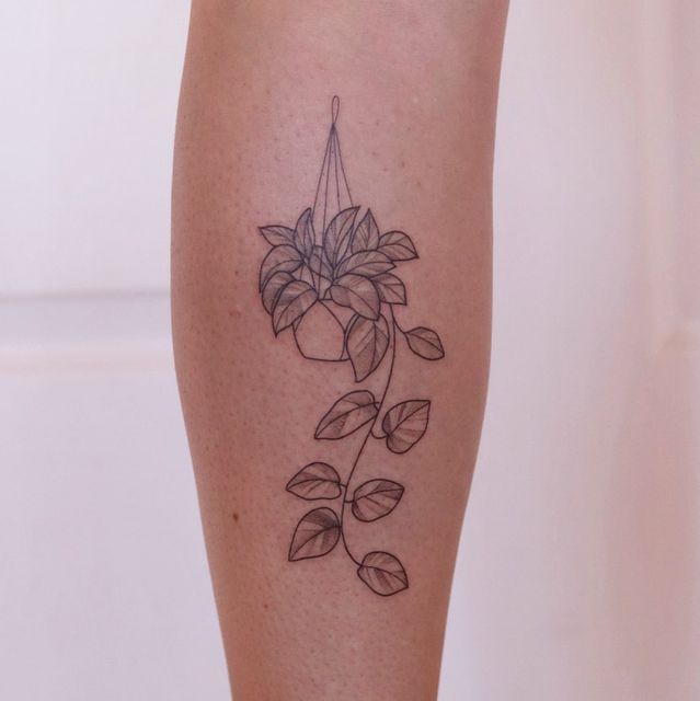 a woman's leg with a tattoo on it that has flowers growing out of it