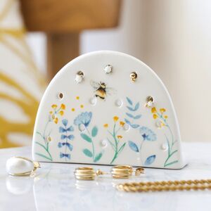 a white purse sitting on top of a table next to a gold beaded chain