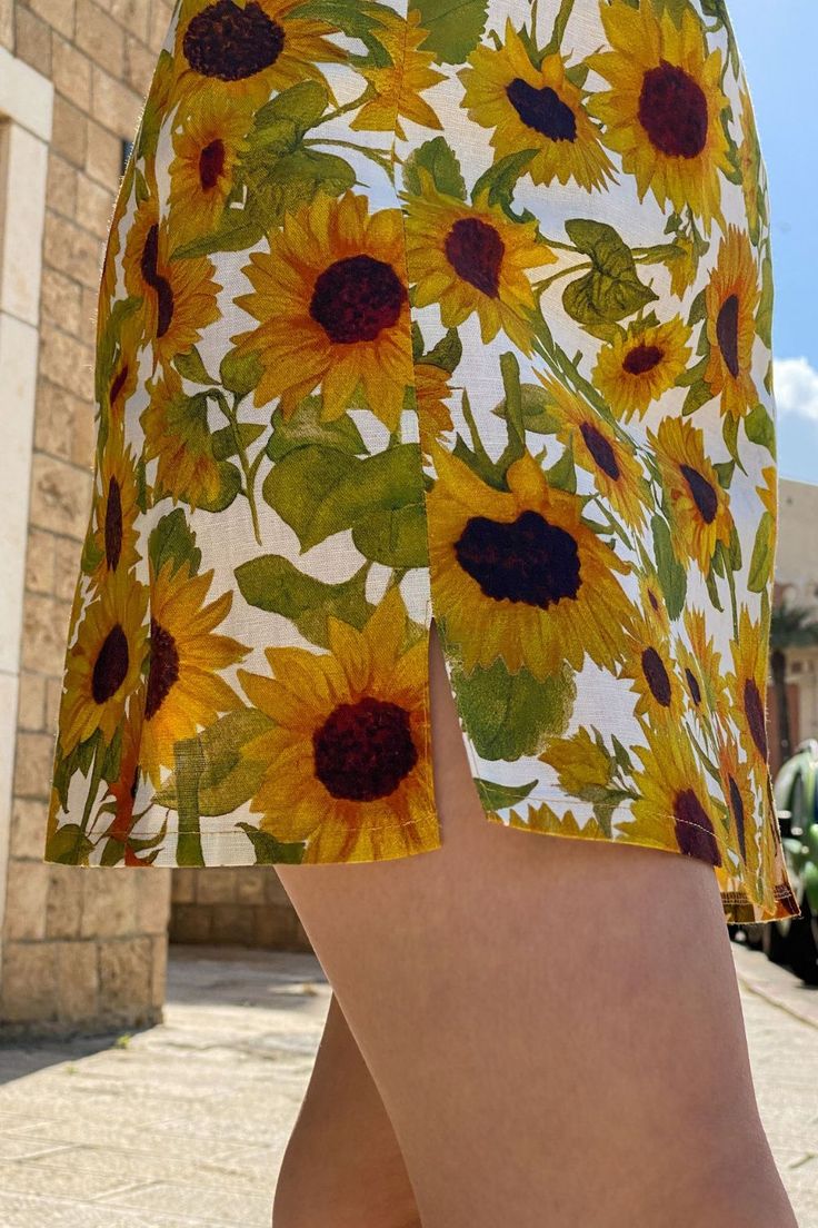 Your next favorite statement piece. Two subtle slits at the front add light detail to the summer mini skirt. A hand painted sunflowers print adorn the skirt. With warm yellow shades emanating bright, cheerful vibes, it's hard not to love this little number. The beautifully hand-painted sunflower print makes this a confidence-boosting style. The Rachel Skirt in Sunees creates a summery, colorful outfit full of vibrant energy. The floral mini skirt is made from 100% linen Multicolor Printed Summer Skirt, Floral Print Mini Skirt For Summer Beach, Fitted Printed Mini Skirt For Summer, Summer Floral Print Mini Skirt For Day Out, Summer Floral Print Mini Skirt For Vacation, Floral Print Summer Vacation Skirt, Summer Mini Skirt With Floral Print For Vacation, Vacation Floral Print Mini Skirt, Floral Print Mini Skirt For Summer Day Out