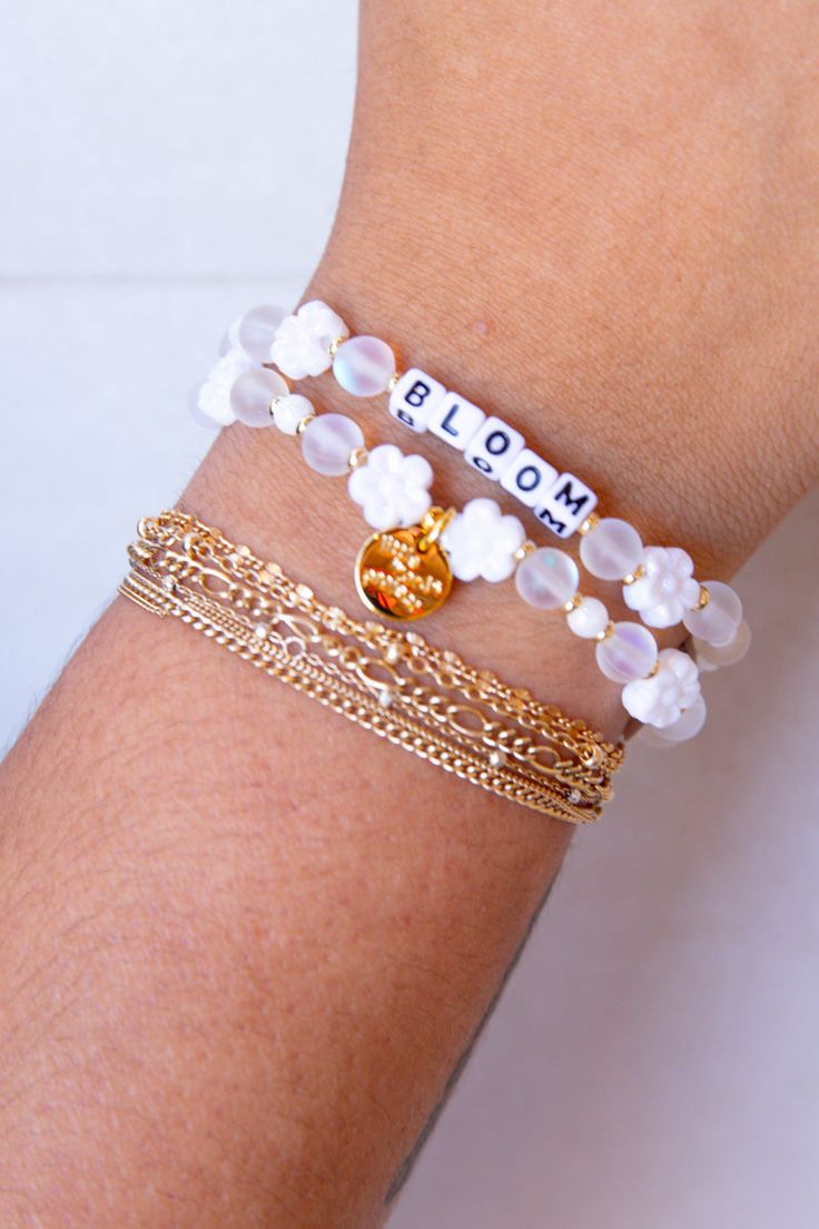 Embrace your personal growth and flourish with our "Bloom" bracelet from Little Words Project. This delicately crafted piece symbolizes new beginnings and the beauty of blooming where you are planted. Perfect for inspiring daily positivity and strength, it features elegant flower beads and a reminder to thrive in all aspects of life. Whether you're treating yourself or gifting a loved one, the "Bloom" bracelet is a chic reminder to keep growing and shining. Celebrate your journey with this beaut Dainty White Hypoallergenic Bracelets, Dainty Hypoallergenic White Bracelets, Dainty White Hypoallergenic Bracelet, Dainty White Charm Bracelet For Everyday, Delicate White Adjustable Jewelry, White Dainty Flower Shaped Beaded Bracelets, Delicate White Flower Beaded Bracelets, Delicate White Flower Shaped Beaded Bracelets, Delicate White Hypoallergenic Jewelry