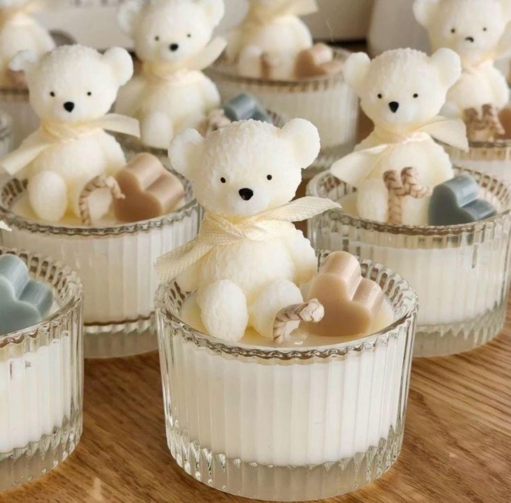 small white teddy bears in glass cups on a table