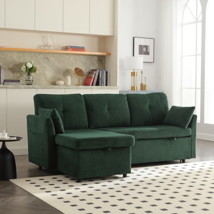 a green couch sitting on top of a white rug