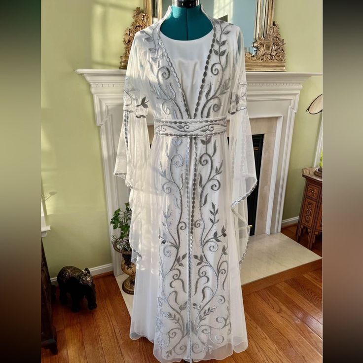 Off White Muslim Wedding Kaftan Abaya Dress With Silver Hand Embroidery. Perfect For Arab/Muslim/Pakistani/Iranian/Bengali/Thobe/Mehr Events. Modest Formal Wear. Three Pieces, Long Satin Long Sleeves Dress And Gorgeous Hand Embroidered Light Fabric On Top, Hidden Zipper In The Back Of The Satin Dress, Comes With Embroidered Matching Belt. Size M. Made With High Quality Materials! Brand New Never Worn! Elegant Silver Gown For Eid, Silver Dress For Wedding And Eid, Silver Wedding Dress For Eid, Silver Dresses For Eid, Festive White Abaya For Eid, Festive Floor-length White Thobe, Silver Wedding Gown For Eid, Fitted Festive Wedding Abaya, Elegant Wedding Festive Thobe