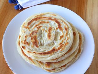 four flat breads on a white plate