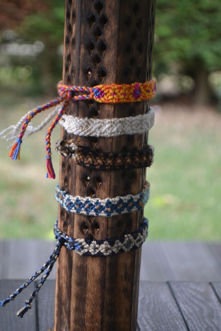 several bracelets tied together on a wooden pole