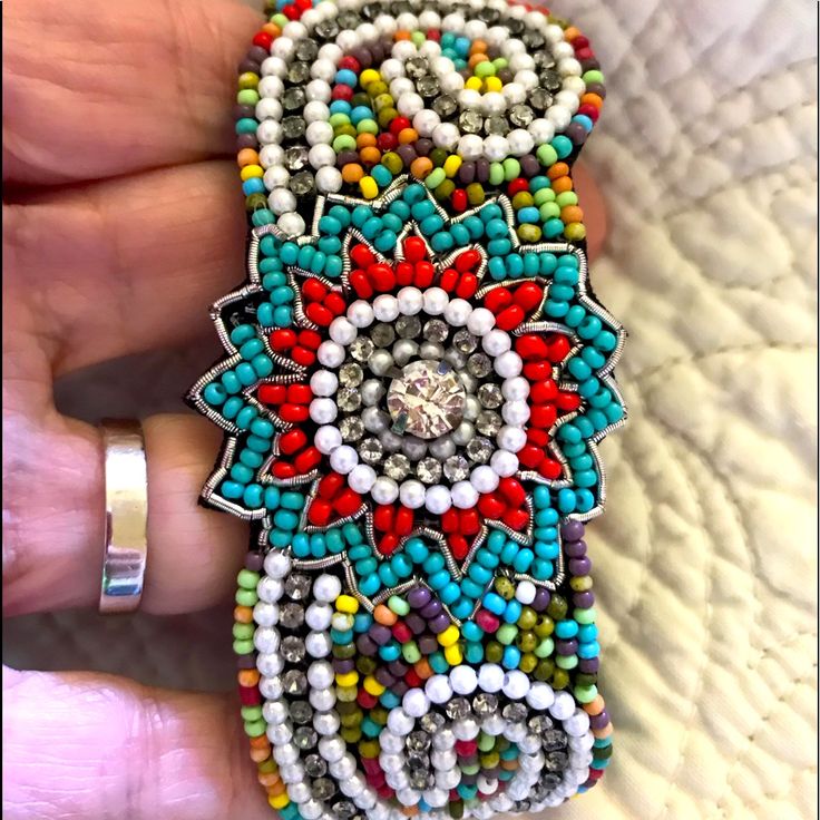 a hand holding a colorful beaded bracelet