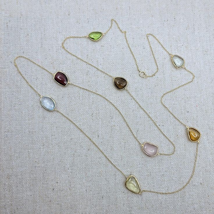 Semi-precious stone with 18k Solid Gold Necklace Stone: Semi-Precious Stone (Citrine, Blue Topaz, Rose Quartz, Lemon Quartz, Garnet, Green Amethyst, Peridot, Smokey Quartz)           -Shape: Free Form           -Cut: Double-Sided Cabochon           -Color: Orange, Blue, Pink, Yellow, Red, Light Green, Brown, Green           -Weight: ~26ct           -Quantity:  8 pieces           -Quality: Please refer to the picture, only 1 piece is available Necklace Length: 81cm (32in) The stones were bezel-se Yellow Multi-stone Round Gemstones, Yellow Gemstones With Accents Fine Jewelry, Gold Multi-stone Fine Jewelry Gemstones, Gold Multi-stone Gemstones In Fine Jewelry Style, Yellow Gold Briolette Gemstones For Formal Occasions, Formal Yellow Gold Briolette Gemstones, Gold Oval Multi-stone Jewelry, Formal Multi-stone Drop Jewelry, Yellow Gold Multi-stone Jewelry Gift