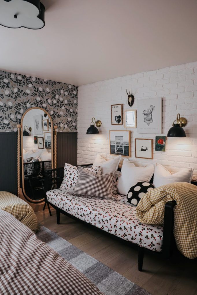 a living room with a couch, mirror and pictures on the wall above it's headboard