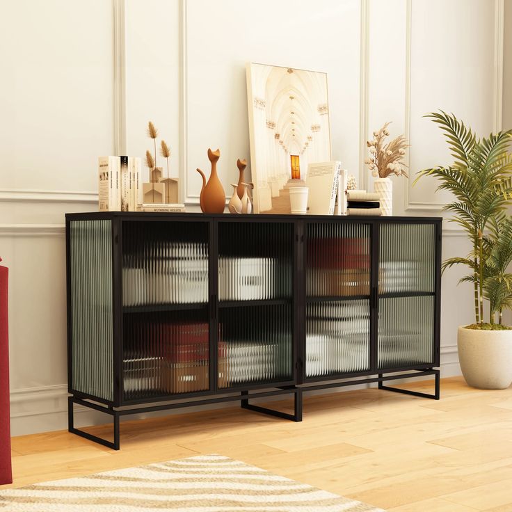 a living room with a bookcase and potted plant on the sideboard in front of it