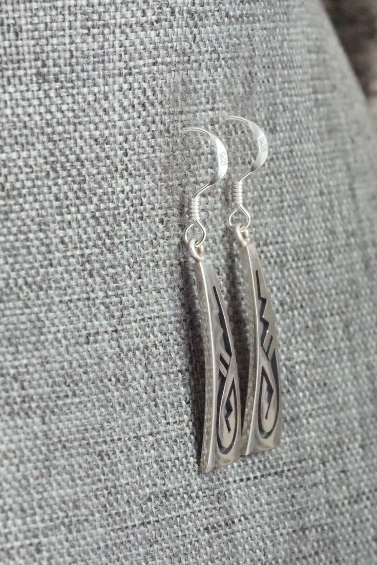 These sterling silver earrings were made by Hopi silversmith Augustine Mowa. The back is stamped sterling.Length: 1 1/2"Width: 3/8"Free shipping on all orders! We ship with USPS and always include tracking. All orders ship within a day of payment.Returns are accepted up to 30 days after you receive your order. Just send us a message. Our shop offers cash back or store credit. The item must be returned in new condition. Classic Engraved Sterling Silver Earrings, Engraved Sterling Silver Dangle Jewelry, Artisan Silver Long Drop Earrings, Artisan Long Drop Sterling Silver Earrings, Artisan Long Drop Silver Earrings, Silver Engraved Teardrop Earrings, Traditional Sterling Silver Engraved Earrings, Engraved Teardrop Sterling Silver Earrings, Traditional Engraved Sterling Silver Earrings