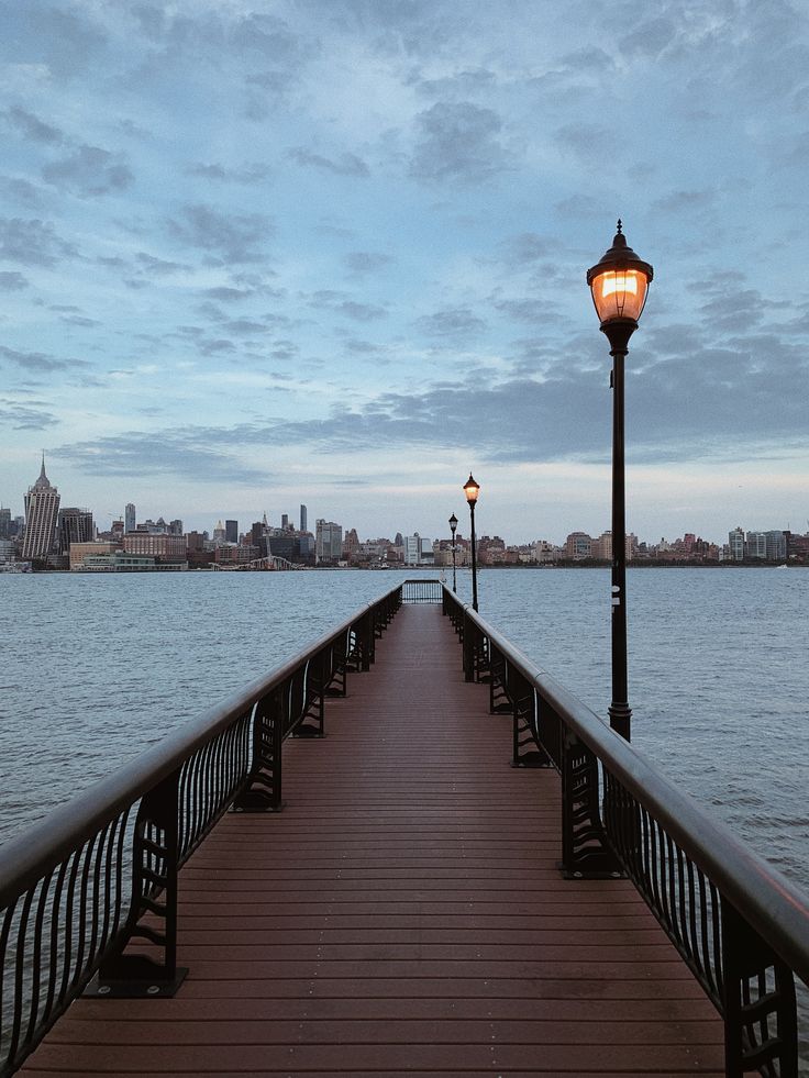 a long pier with a light on it next to the water