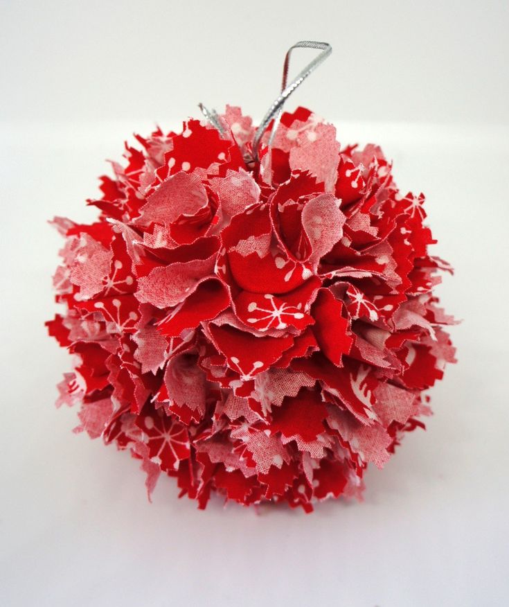 red and white paper flowers are arranged in a ball