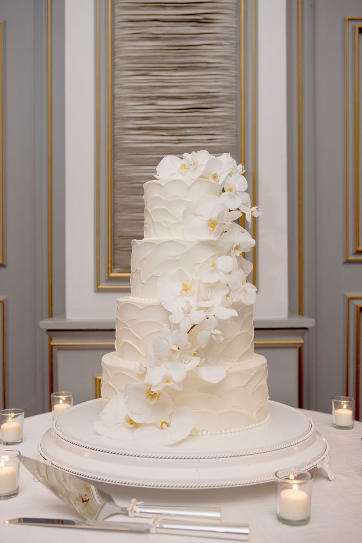 a wedding cake with white flowers and candles