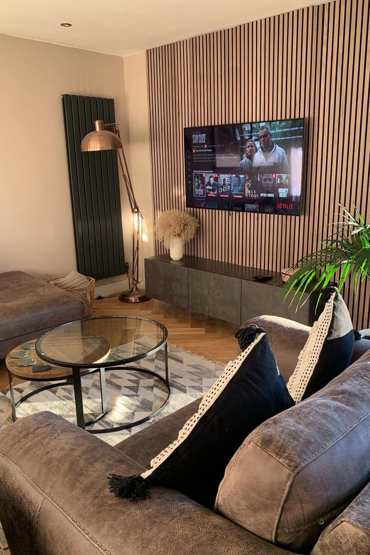 a living room filled with furniture and a flat screen tv mounted on the wall above it