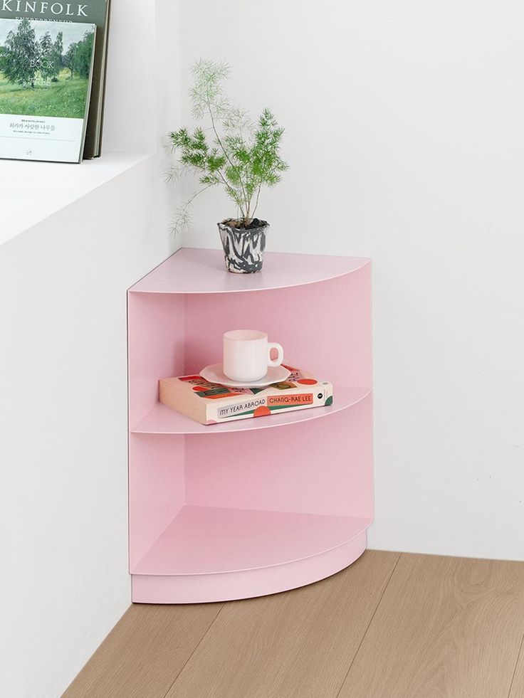 a pink shelf with books and a cup on it