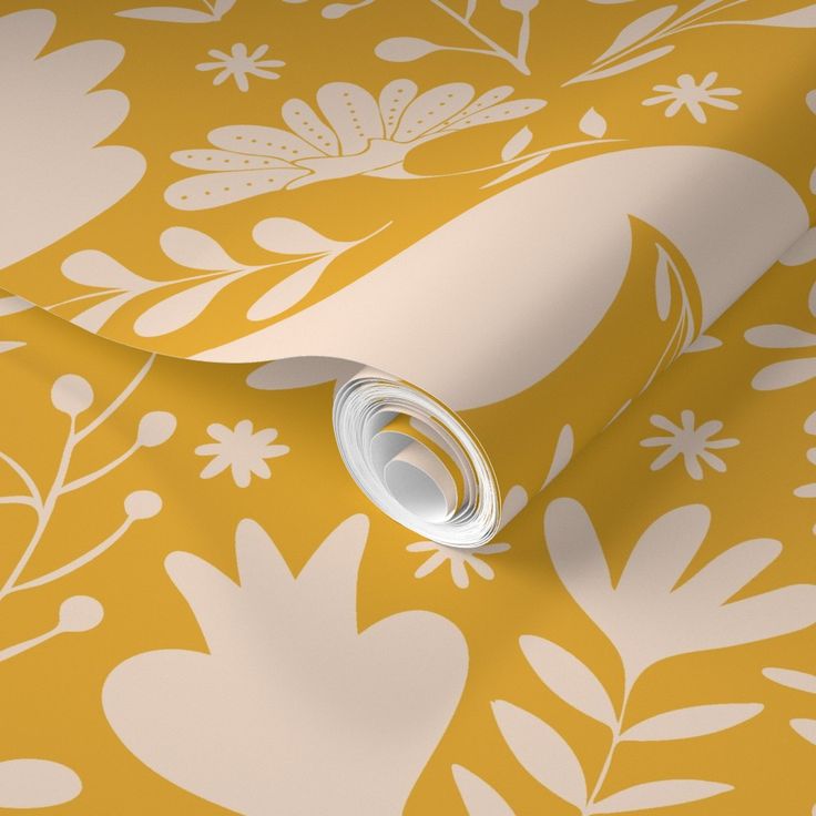 a yellow floral wallpaper with white flowers and leaves on the background is an image of a rolled up roll of toilet paper