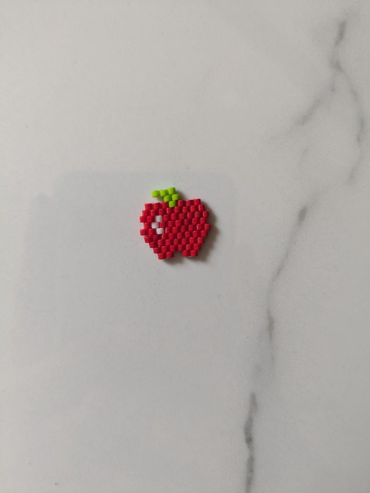 an apple made out of beads sitting on top of a table