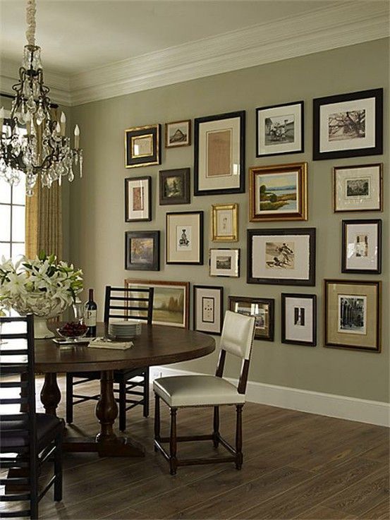 a dining room table with chairs and pictures on the wall