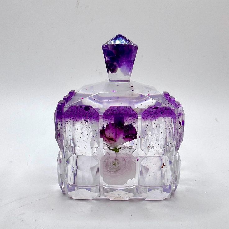 a purple glass box with flowers in it