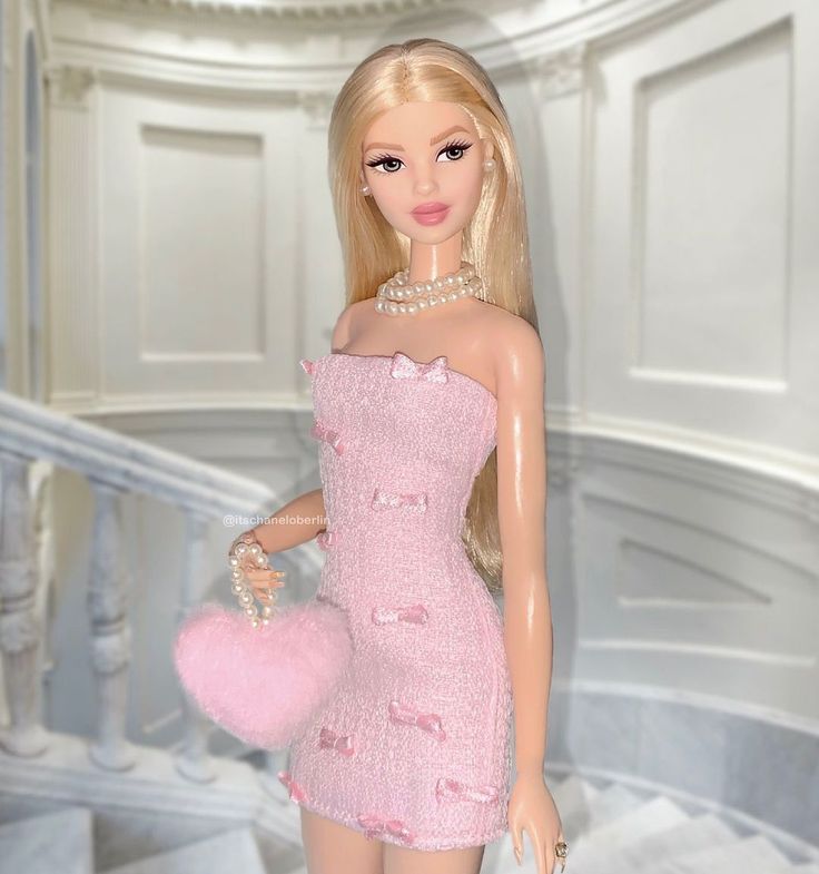 a barbie doll is wearing a pink dress and holding a handbag in her right hand