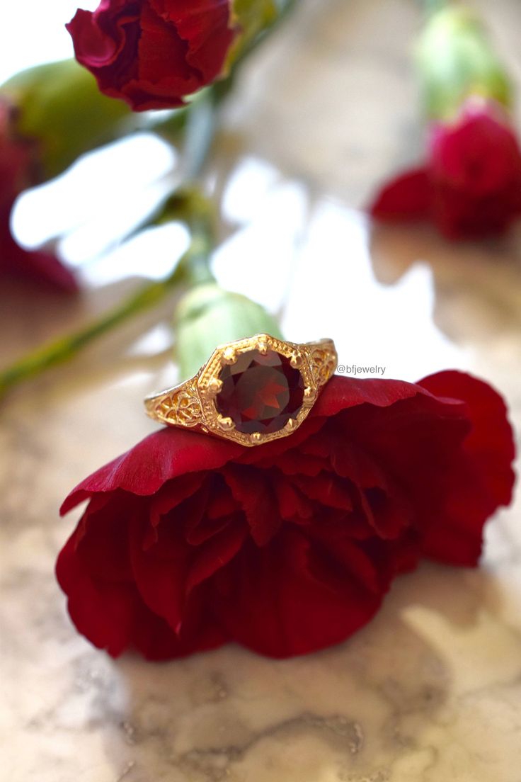 Metal: 14kt Yellow Gold Stone: Garnet Shape: Round Garnet Weight: 1.65 ctw Ring Size: 5 1/2 Sizing: Please state ring size in the personalization box. Weight of entire piece with stones: 3.50grams Width Of Top Part Of Ring : 10mm Customization: We can custom make this ring with any gems and metals. Please inquire if interested. White Gold Amethyst Version: https://www.etsy.com/listing/231479258/sale-vintage-style-14k-white-gold?ref=shop_home_active_7&frs=1 Rose Gold Aquamarine Version: https Gold Garnet Ring, 1 Rose, Garnet Ring, Gold Stone, Gold Filigree, Garnet Rings, Statement Rings, Garnet, Heart Ring