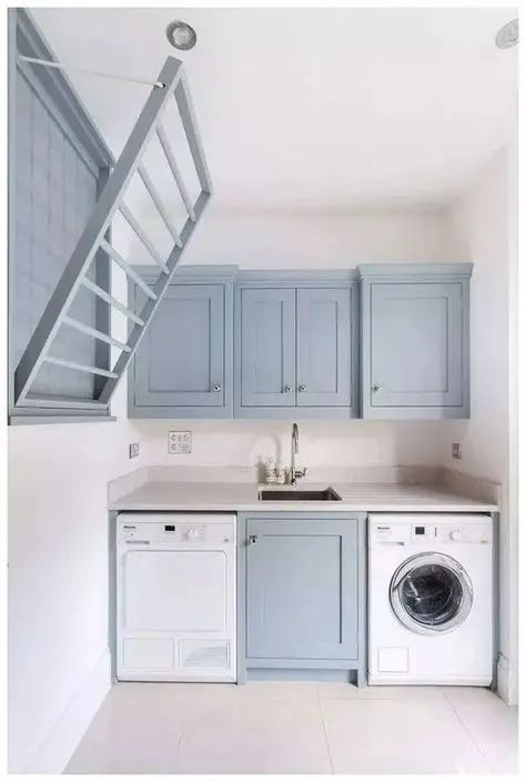 a washer and dryer in a small room with stairs leading up to the second floor