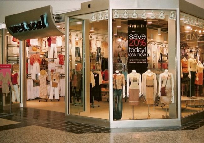 a store front with several mannequins in the window and clothes on display