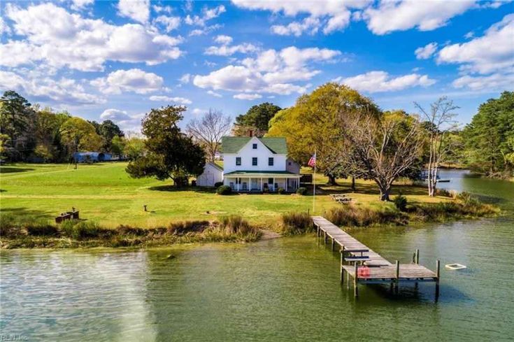 an aerial view of a house on the water with a dock in front of it